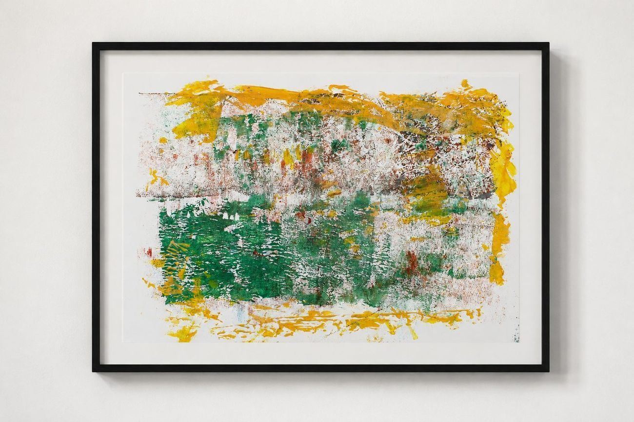 A green and yellow print with orange flecks, in a black frame
