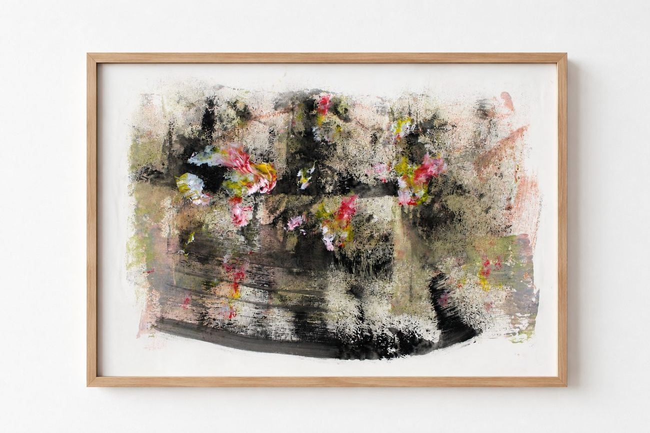 A dark work on paper with pink and yellow blooms, in a pale oak frame
