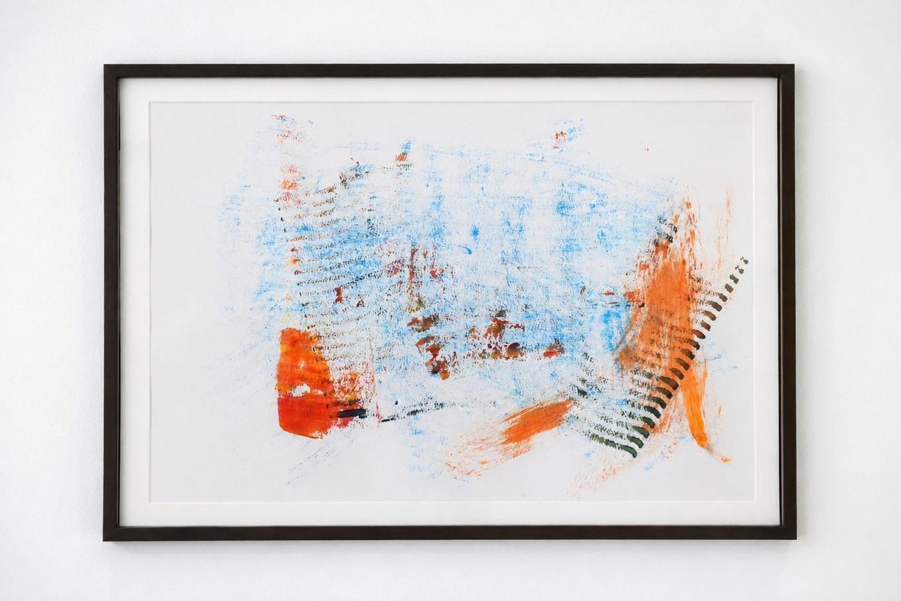 A pale drawing with blue and orange scribbles, in a dark frame