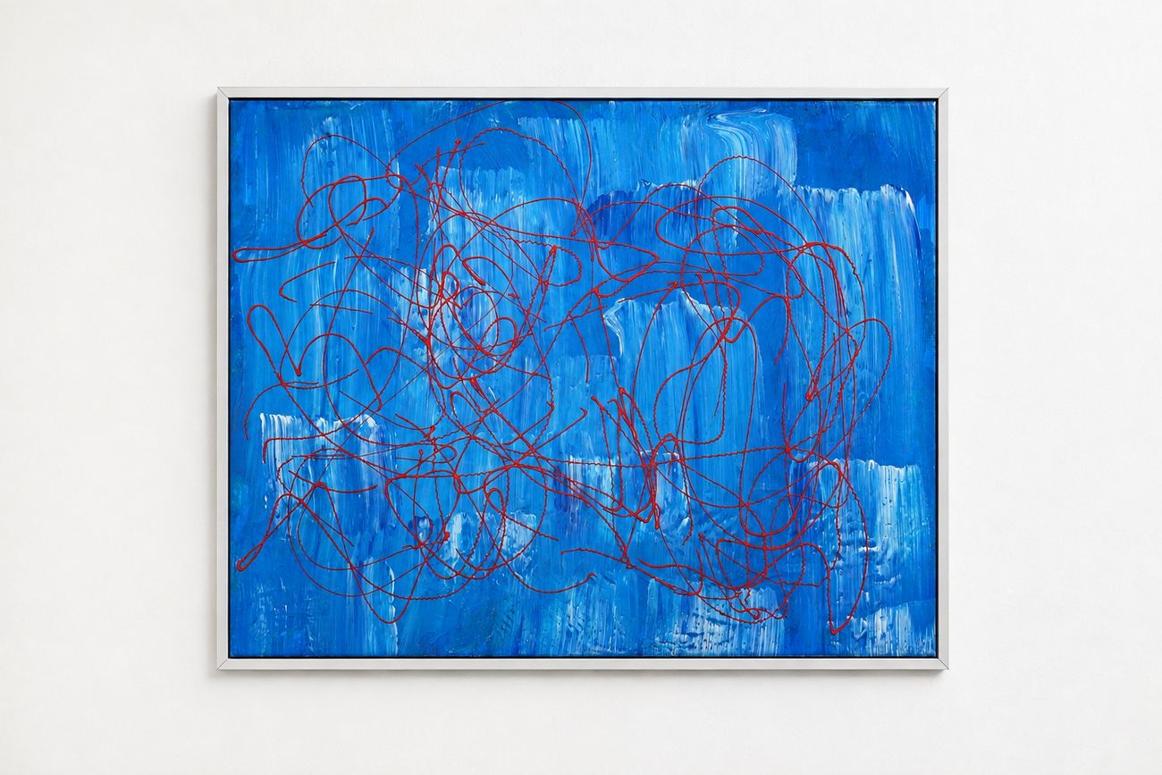 A blue canvas with red looping lines, in a silver frame