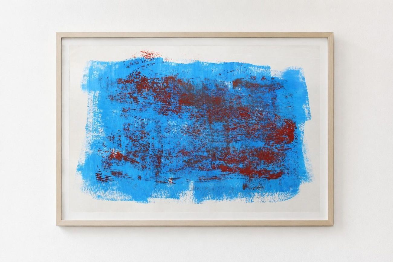 A bright blue work with dark red scraped through it, in a pale frame